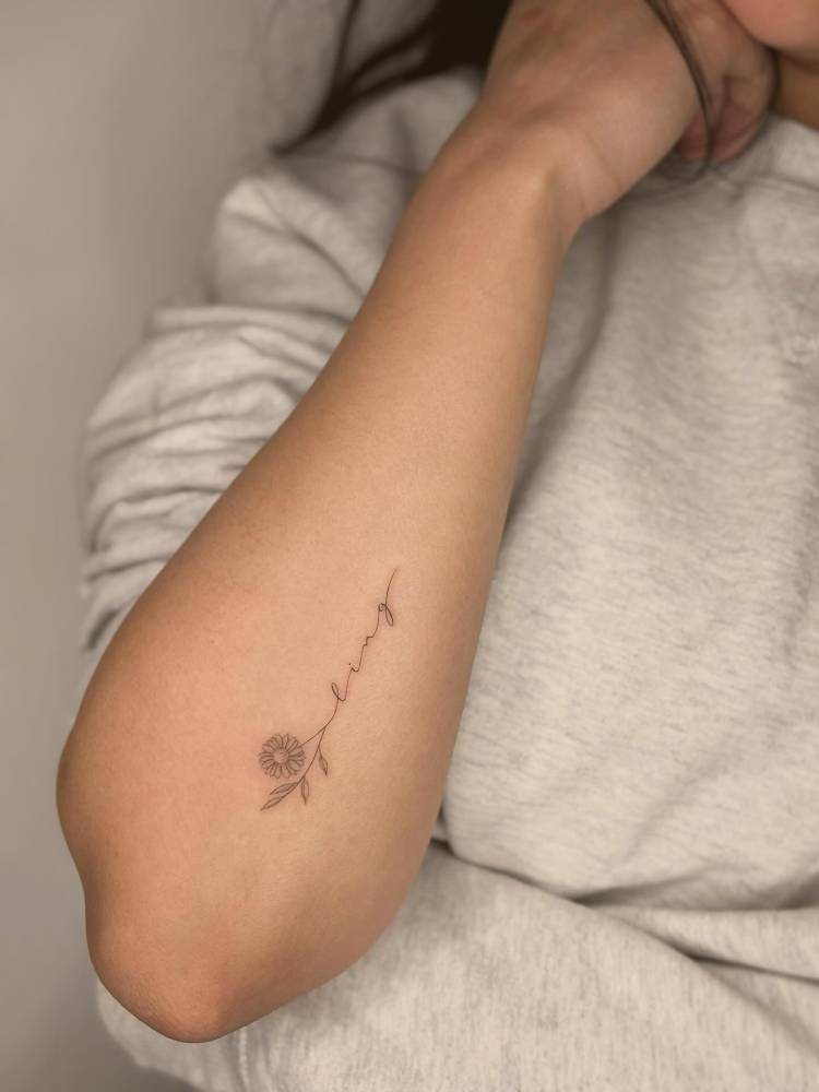 Name "Ling" and sunflower tattooed on the forearm, fine line style.