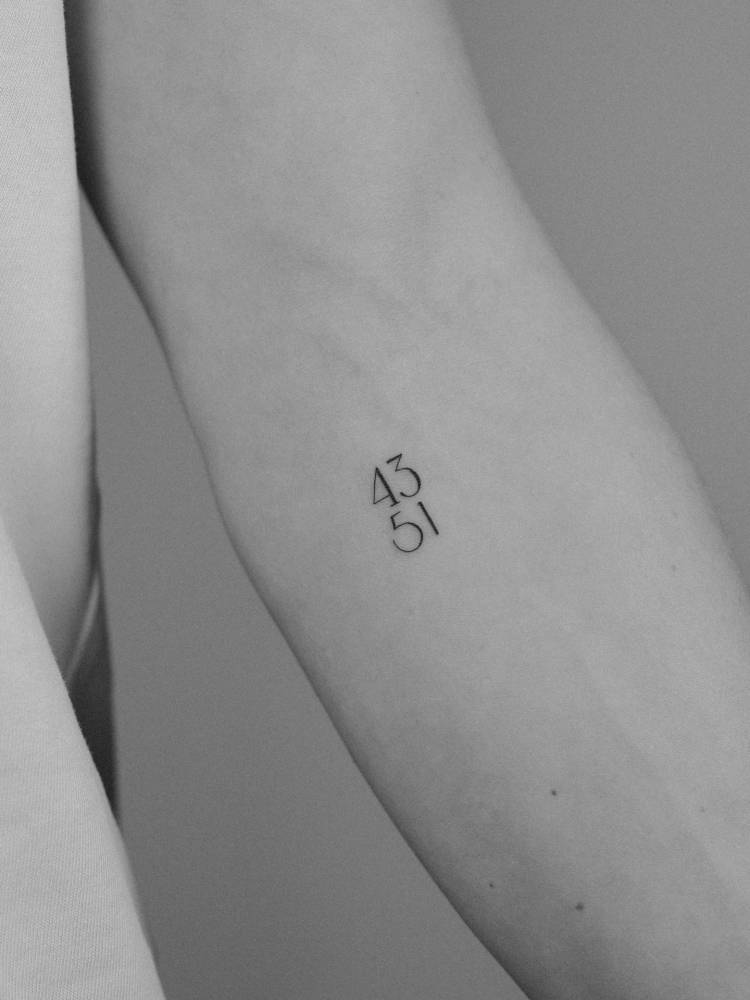 Numbers "43" and "51" tattooed on the inner forearm.