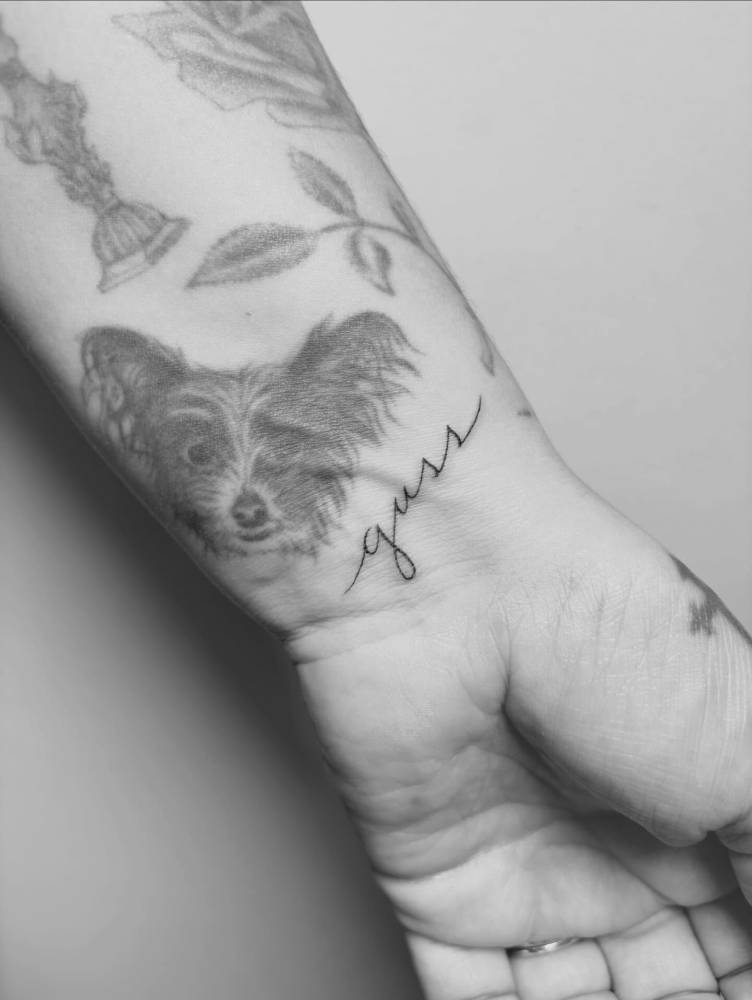 "Guss" lettering tattoo located on the wrist.