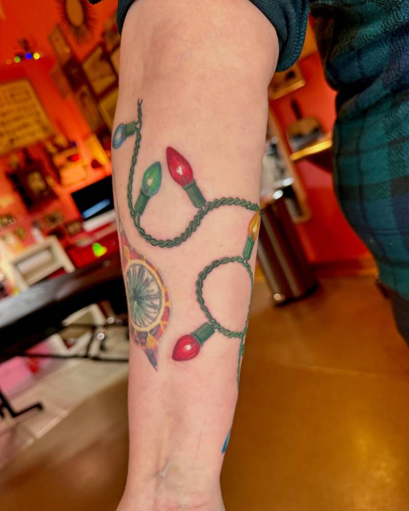 Christmas Lights tattoo located on the inner forearm.