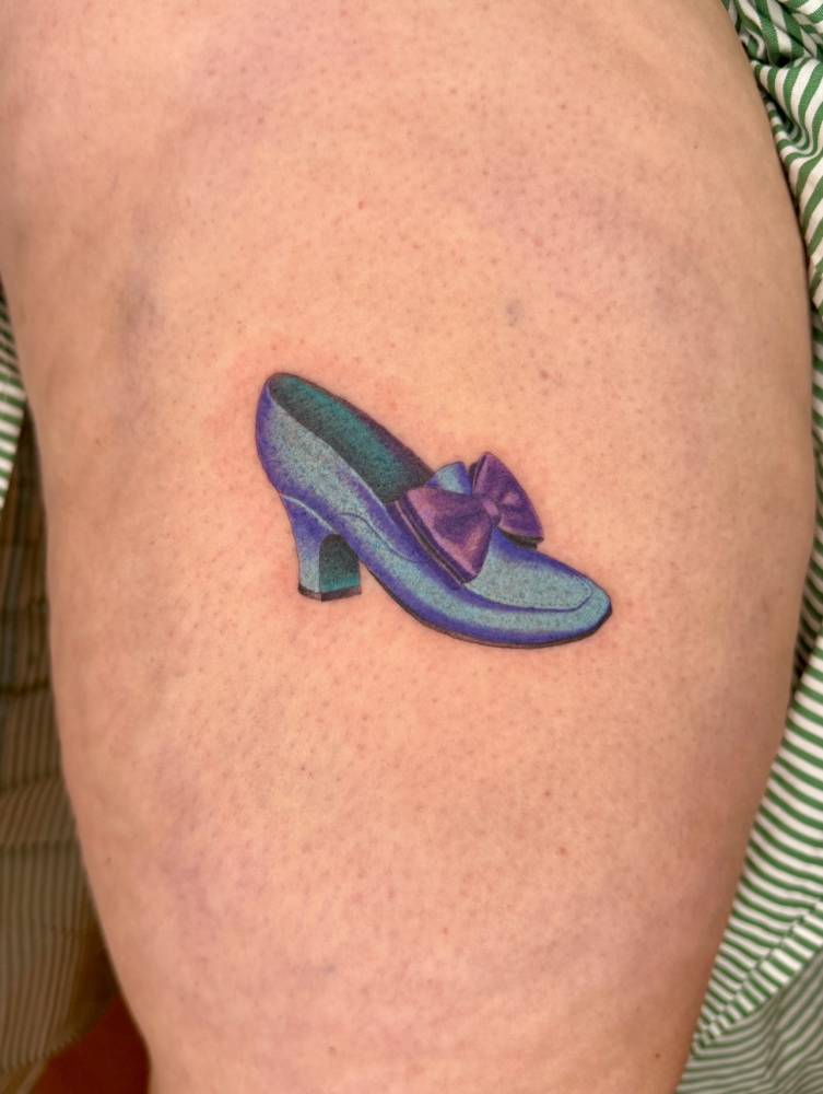 Mary Poppins inspired shoes tattooed on the thigh.