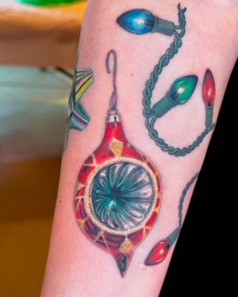 Christmas ornament tattoo located on the inner forearm.