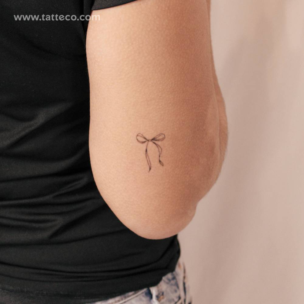 Ribbon bow semi-permanent tattoo located on the tricep.