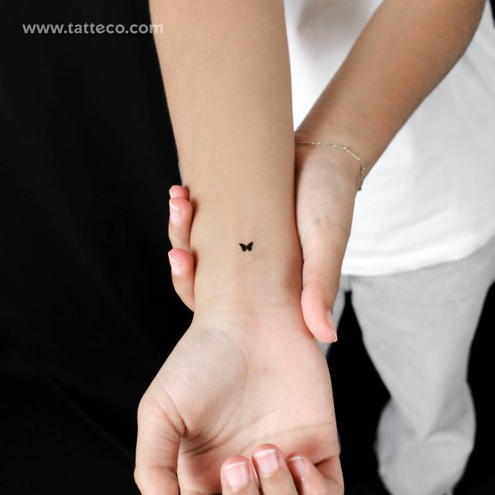 Tiny minimalistic butterfly semi-permanent tattoo.