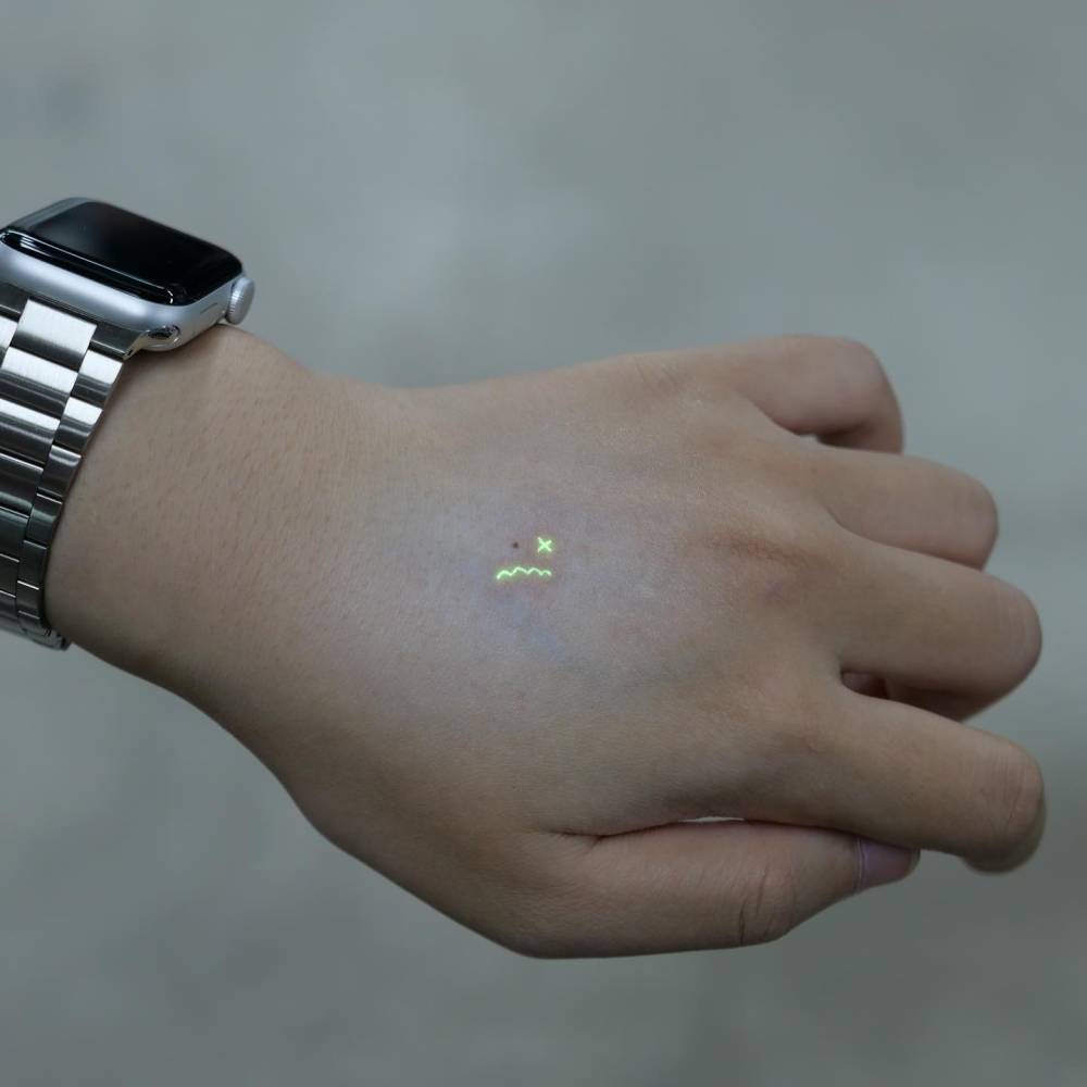 Tiny minimalistic sad face tattoo located on the hand.