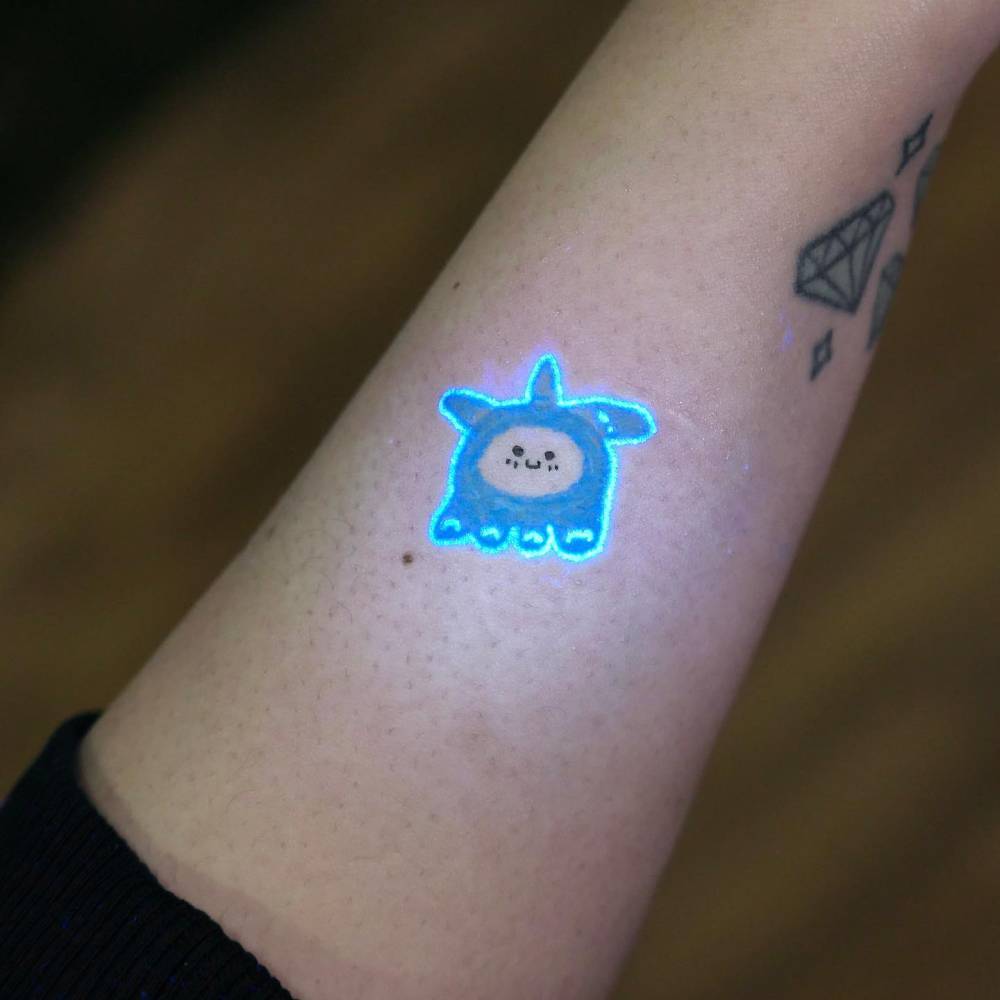 Baby jellyfish tattoo in cartoon style located on the wrist.
