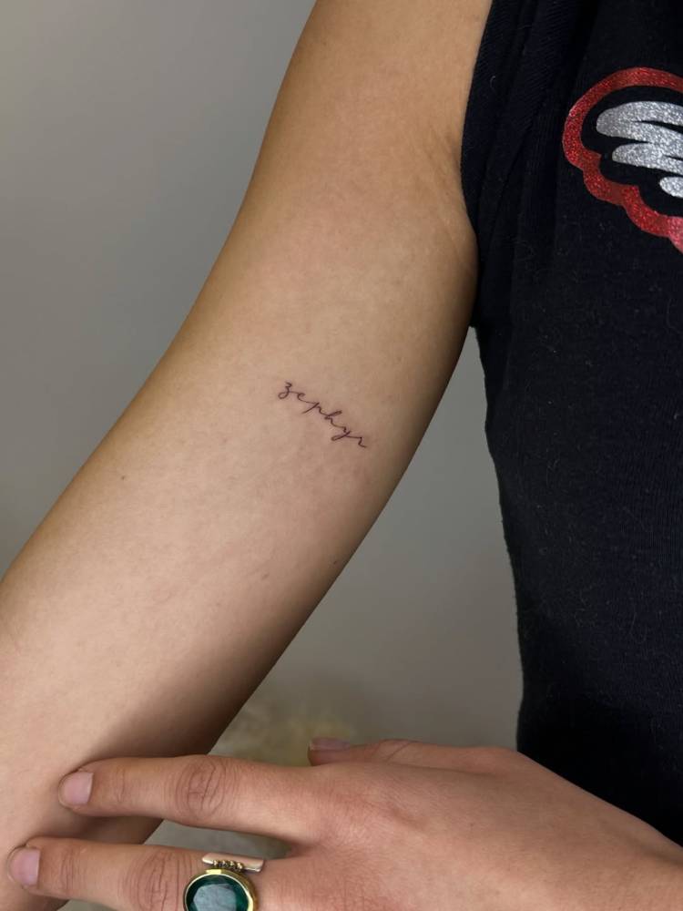 "Zephyr" lettering tattoo located on the inner arm.