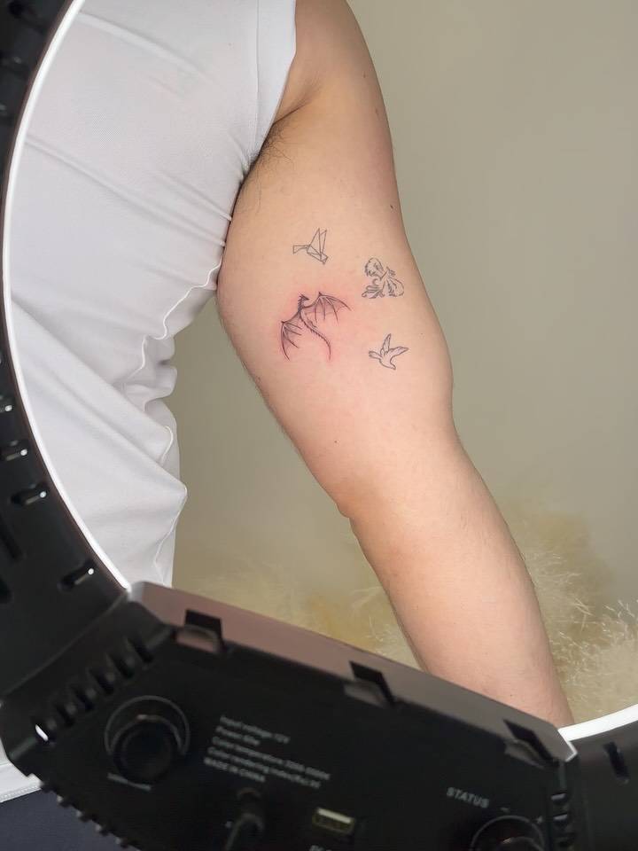 Illustrative style dragon tattoo located on the inner arm.