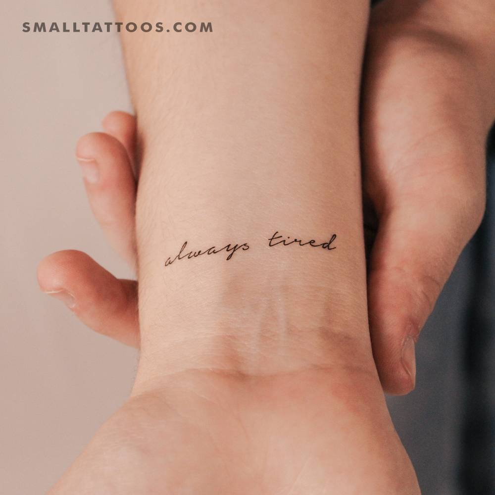 "Always tired" temporary lettering tattoo located on the wrist.