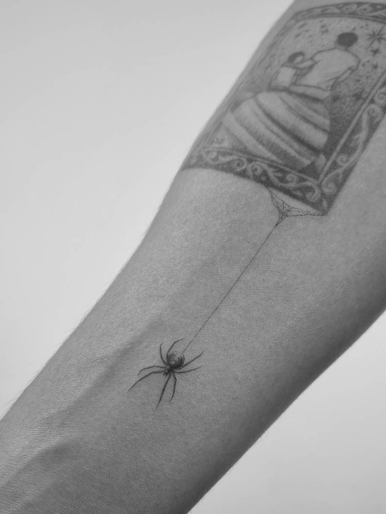 Little spider tattoo in illustrative style done on the inner forearm.