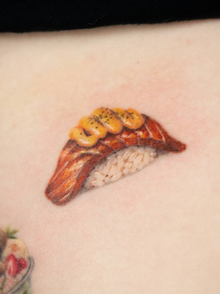 Salmon nigiri tattoo in micro-realism done on the rib.