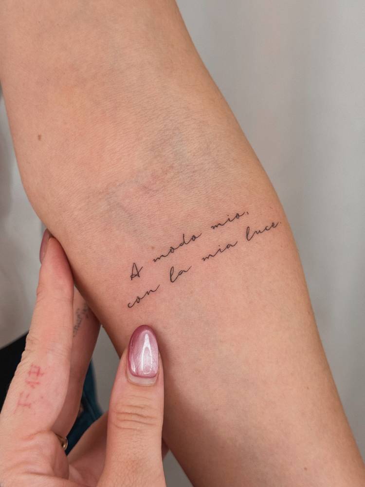 "A modo mio con la mia luce" lettering tattoo located on the inner forearm.