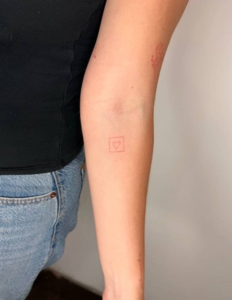 Square and heart tattoo in fine line style placed on the inner forearm.