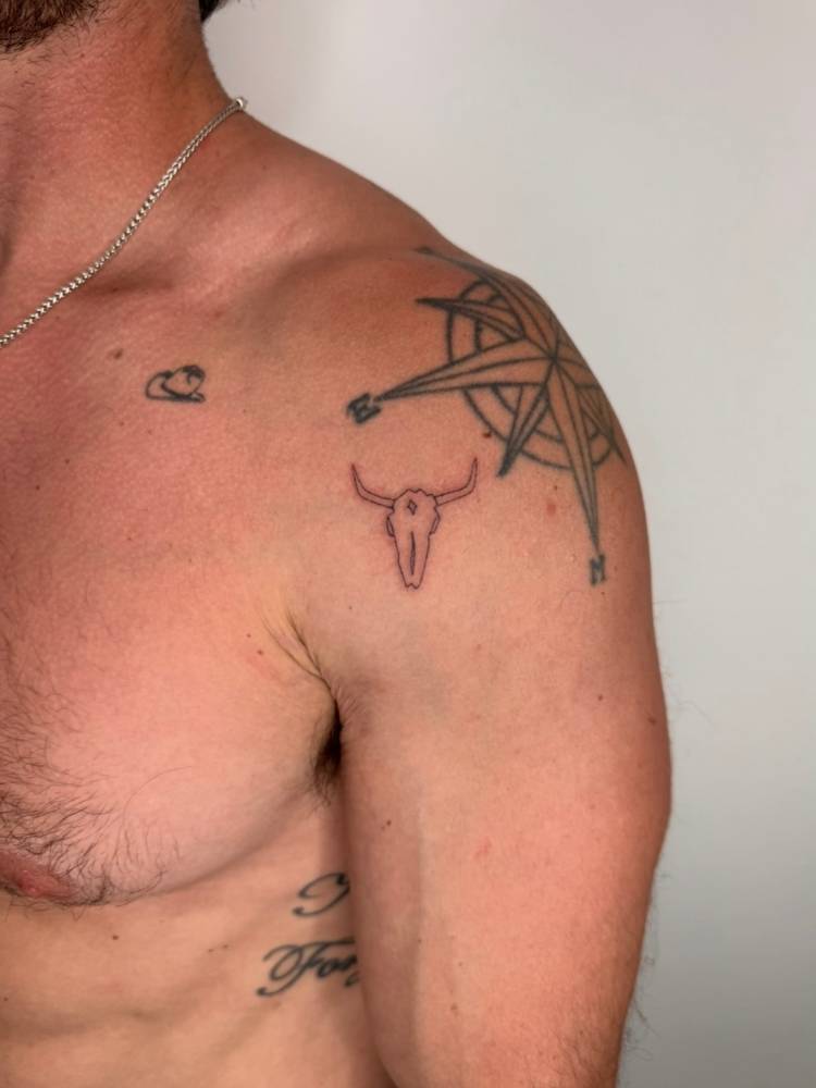 Fine line style bull skull tattoo placed on the shoulder.