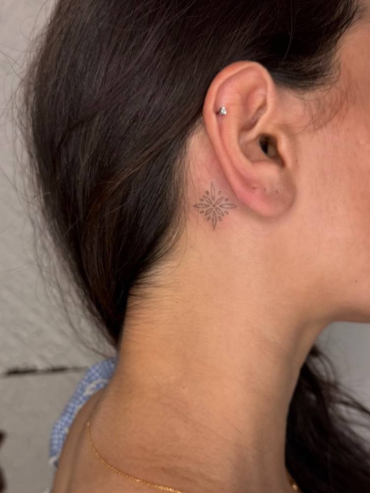Ornamental design tattooed behind the ear.