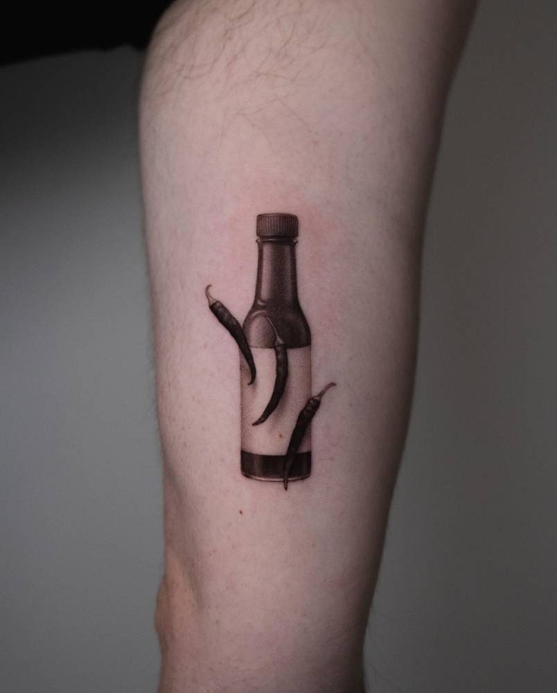 Hot sauce tattoo located on the inner arm, micro-realistic style.