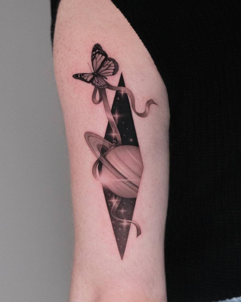 Micro-realistic style butterfly and Saturn tattoo located on the tricep.