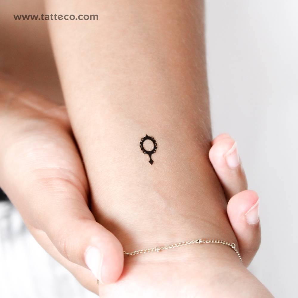 Tiny minimalist mirror temporary tattoo located on the wrist.