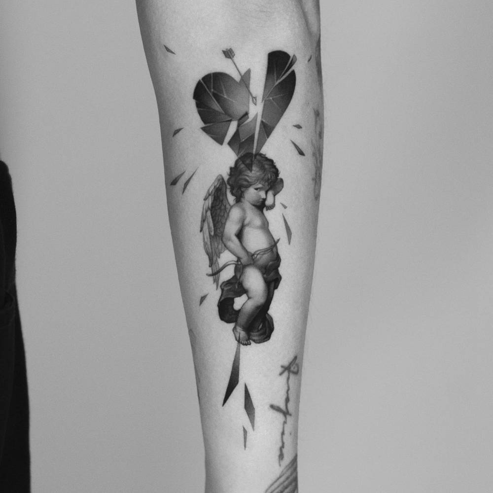 Cupid tattoo in classical style located on the inner forearm.