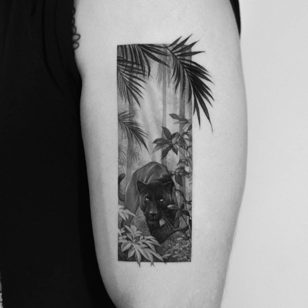 Black panther tattoo in micro-realism located on the upper arm.