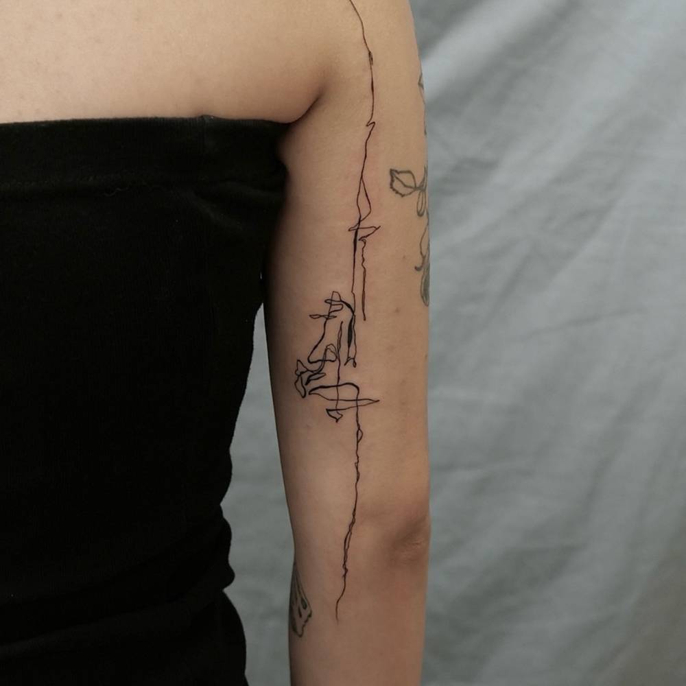 Sketch work style abstract tattoo located on the arm.