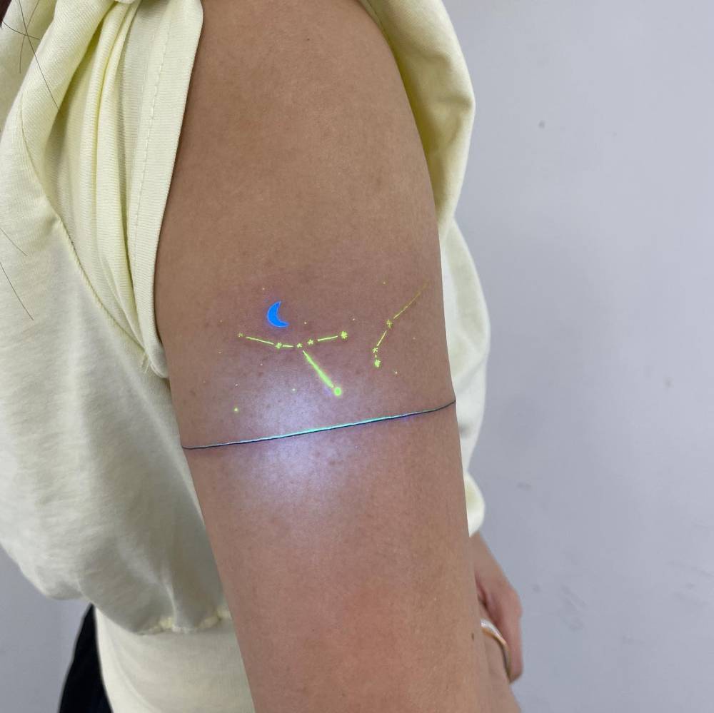 Cancer and Aries constellations tattooed on the upper arm.