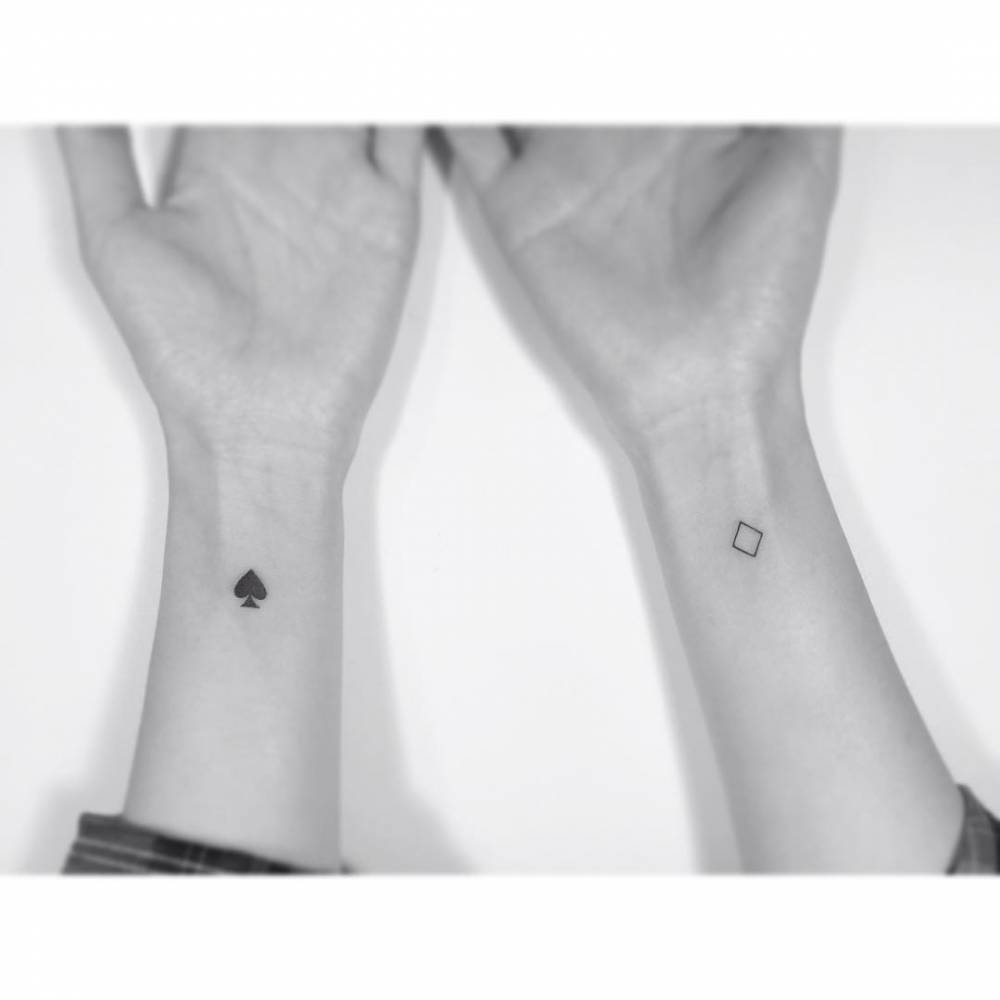 Individual matching spade and diamond suits tattooed on the wrists.