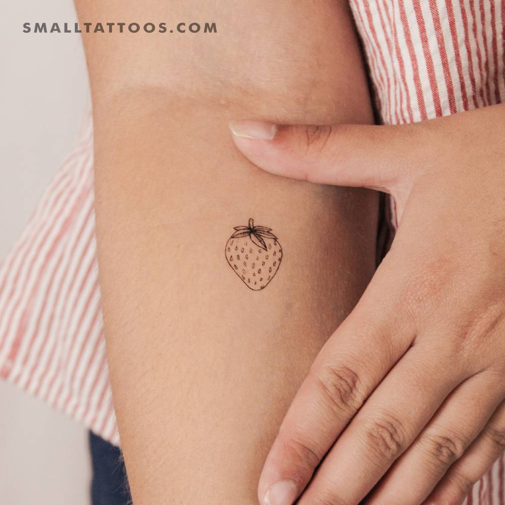 Fine line style strawberry temporary tattoo located on the inner forearm.