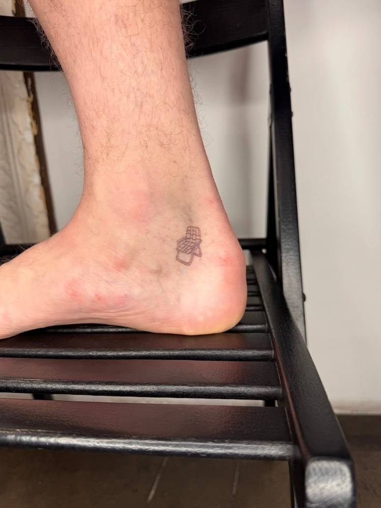 Single needle beach chair tattoo located on the ankle.