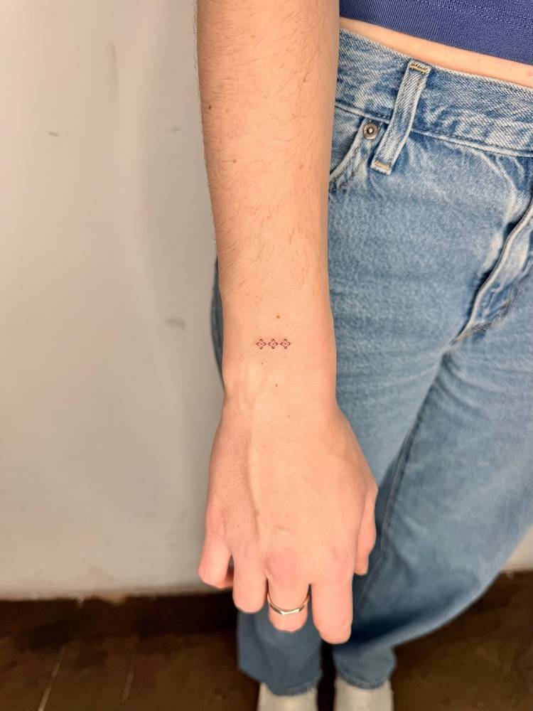 Minimalistic little ornaments tattooed on the wrist.