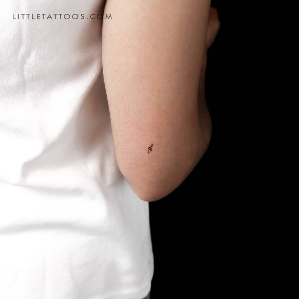 Little minimalistic treble clef temporary tattoo located on the tricep.