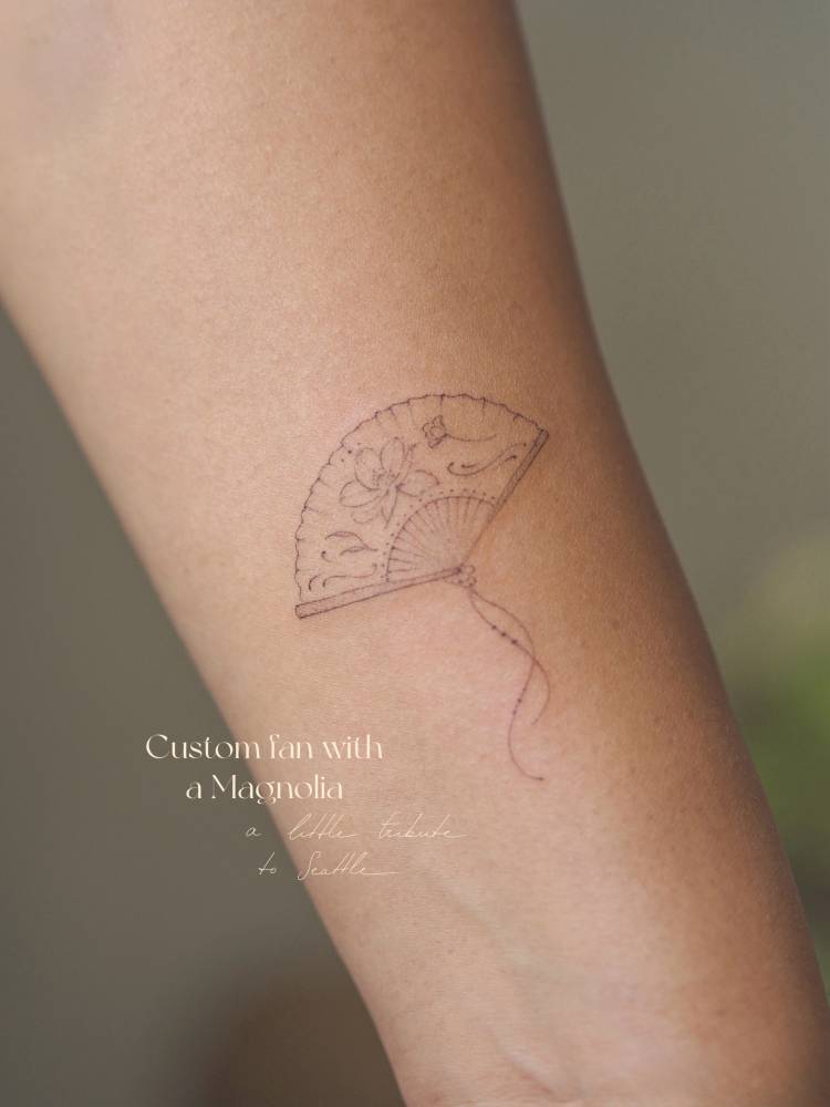 Fine line style hand fan tattoo placed on the inner forearm.