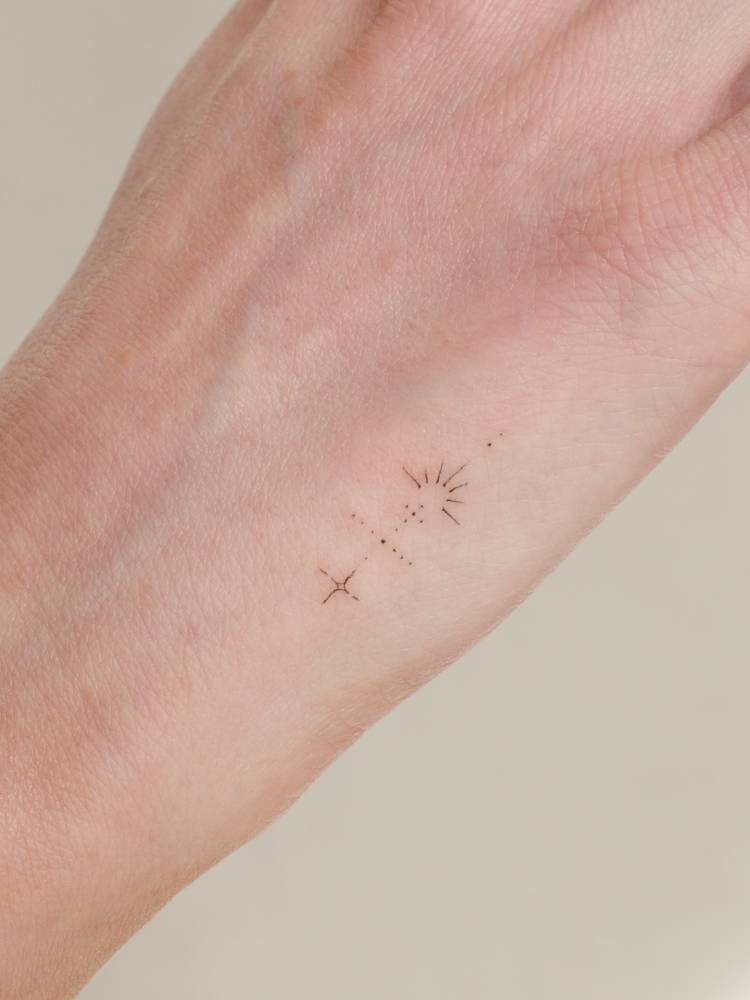 Tiny ornamental design tattooed on the hand.