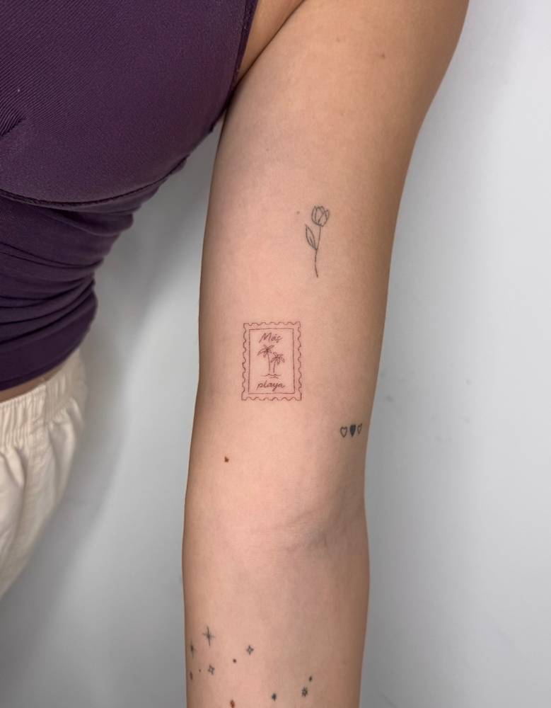 Palm trees stamp tattoo located on the inner arm.