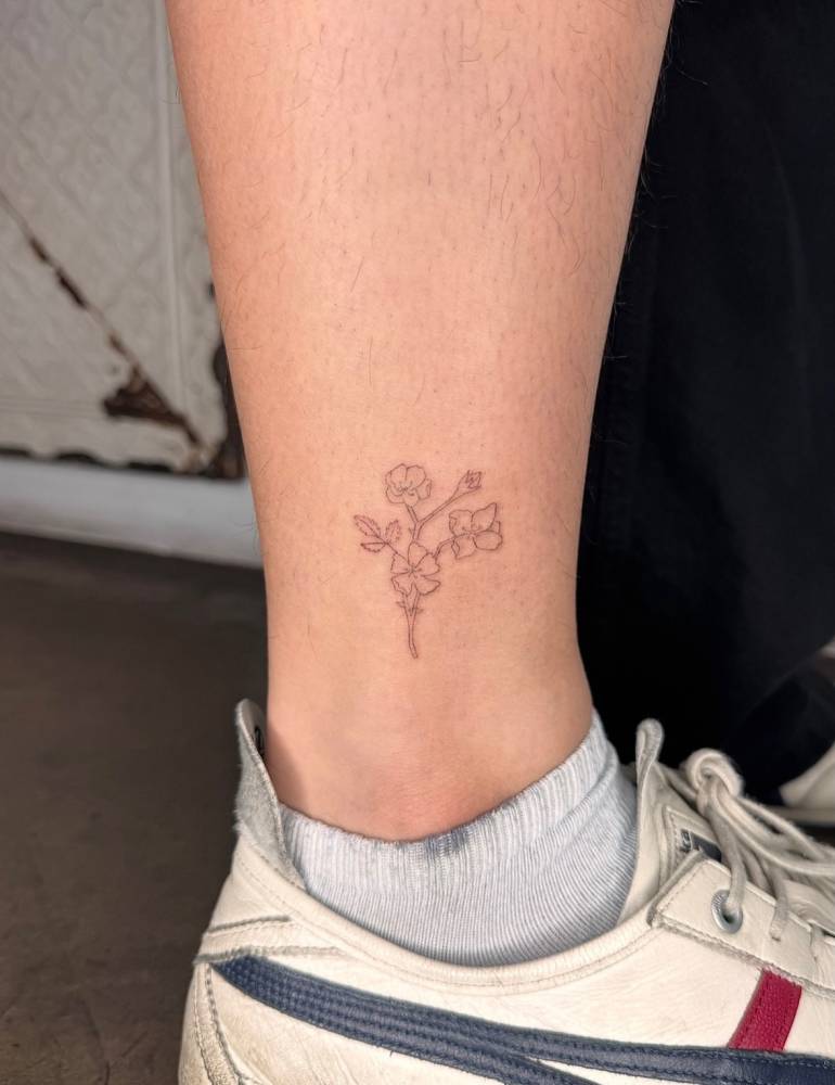 Flower bouquet tattoo placed on the ankle, fine line style.