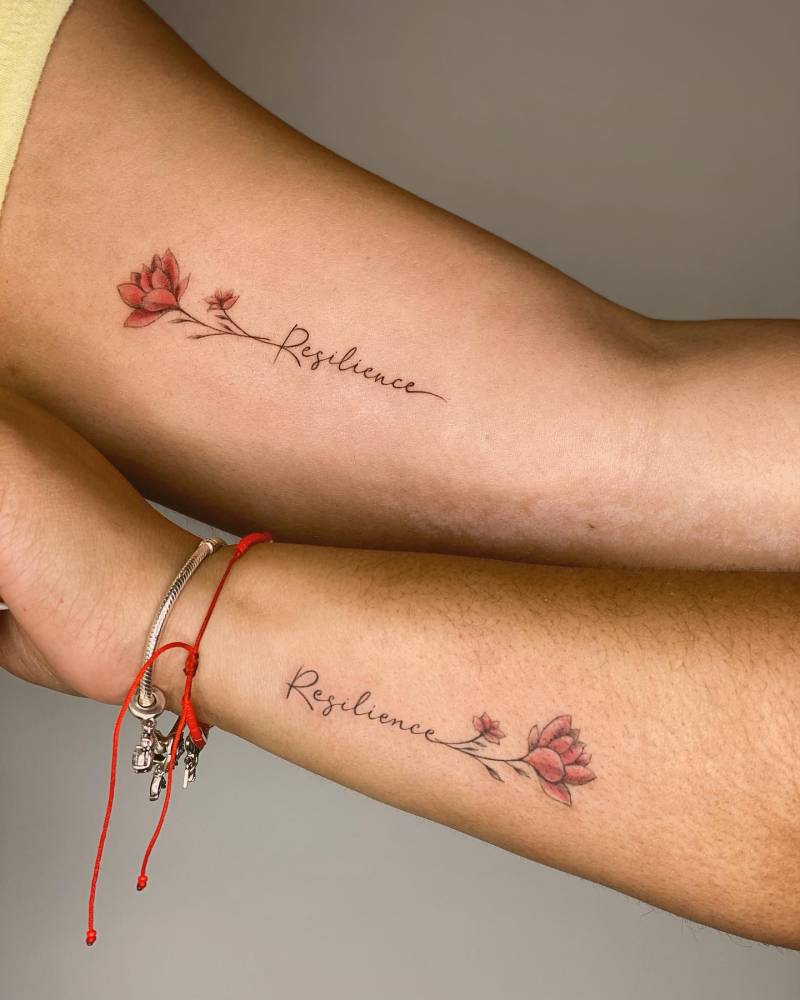 Matching lotus flower and word "resilience" tattoo for best friends.