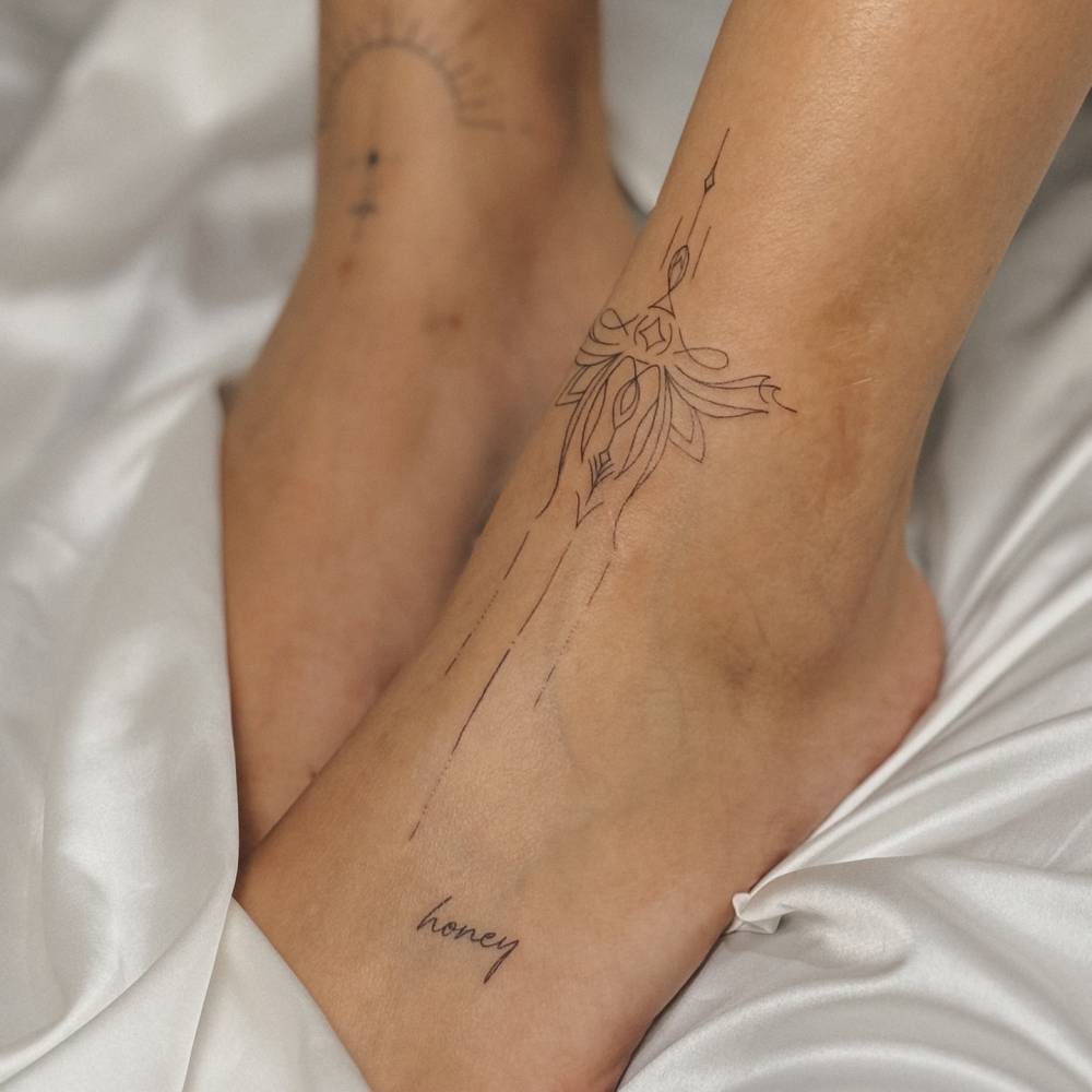 Ornament and word "honey" tattoos in fine line style.
