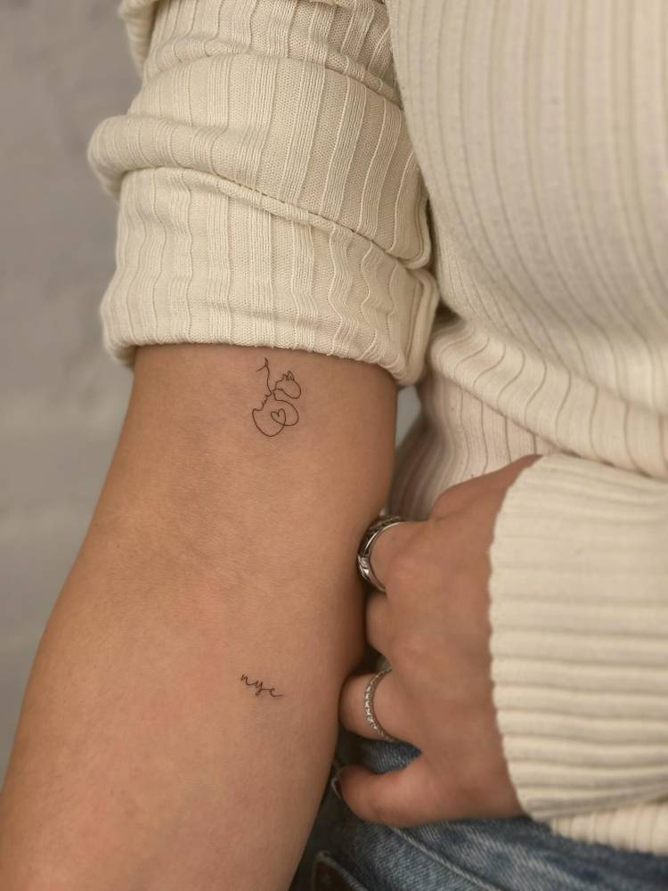 One line dragon and "nyc" tattoos located on the arm.
