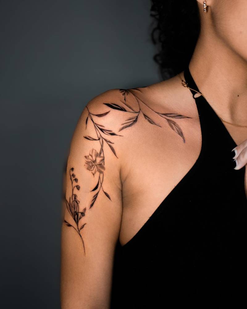 Floral design tattooed on the shoulder, illustrative style.