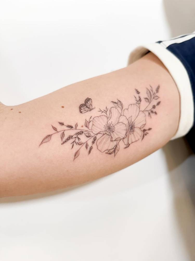 Dog rose tattoo in illustrative style located on the inner arm.