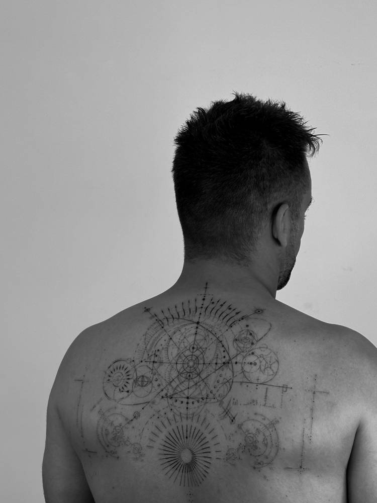 Graphic style geometric design tattooed on the back.