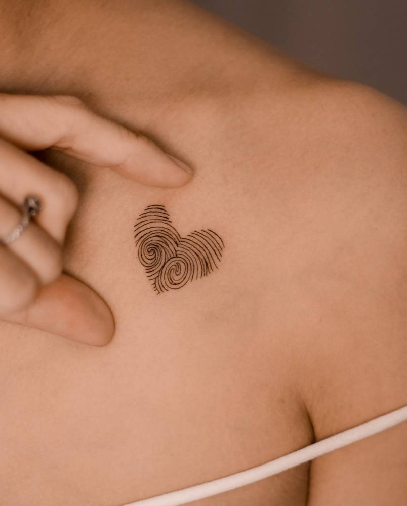 Fingerprint heart tattoo located on the chest.