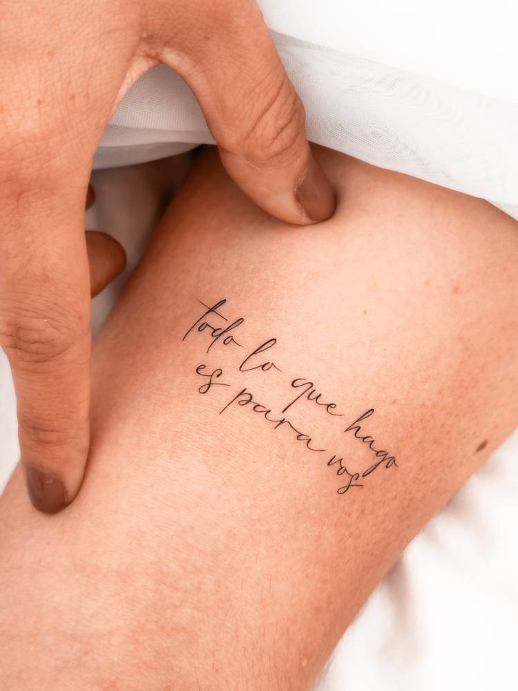 "Todo lo que hago es para vos" lettering tattoo located on the bicep.