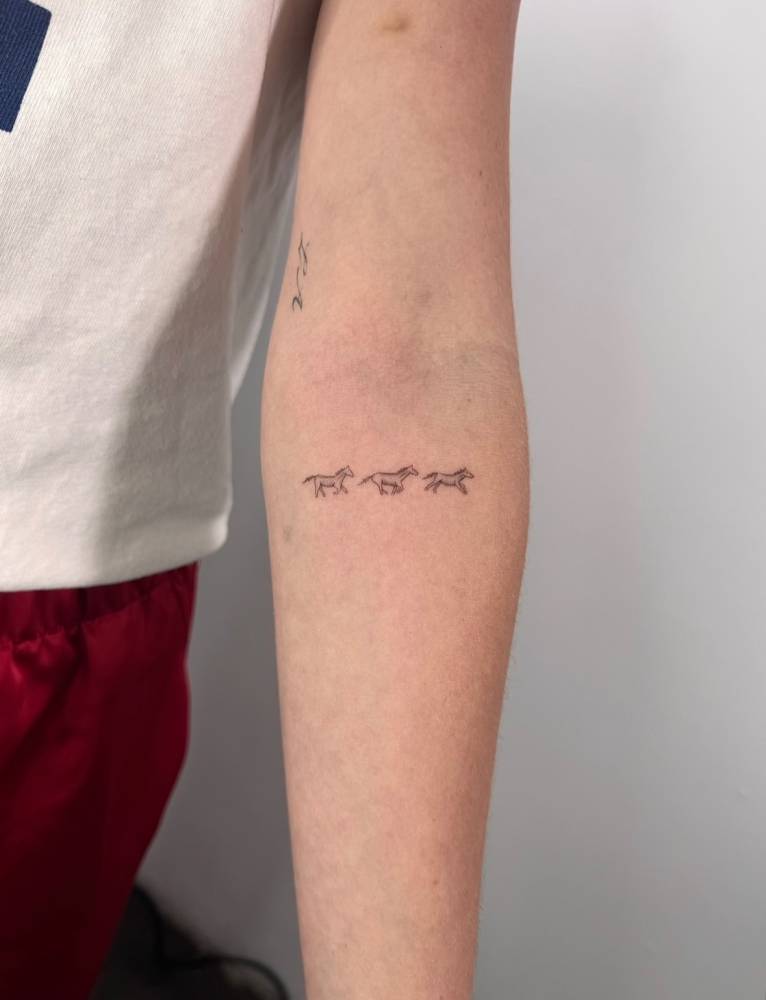 Three little horses tattoo located on the inner forearm.