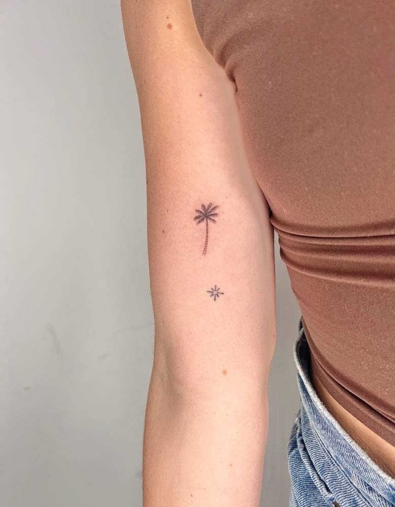 Single needle palm tree tattoo located on the inner forearm.
