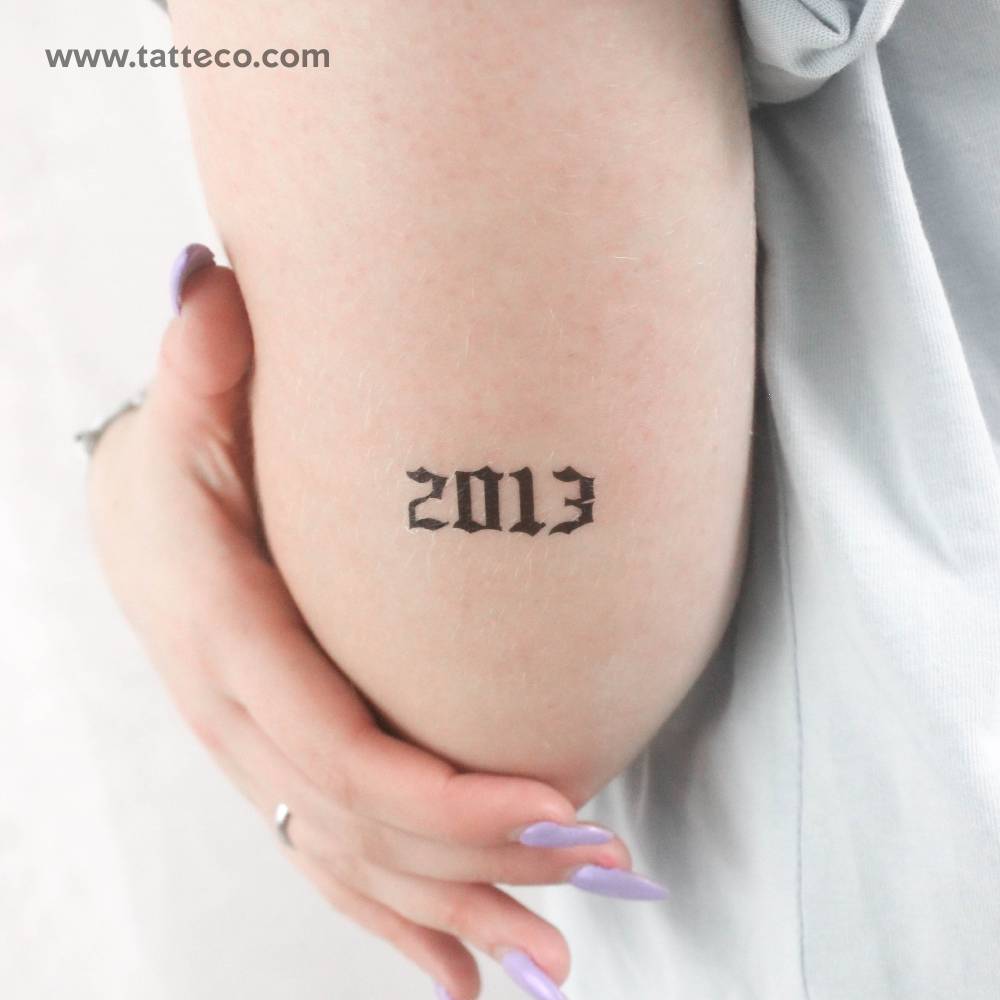 Gothic font "2013" temporary tattoo placed on the tricep.