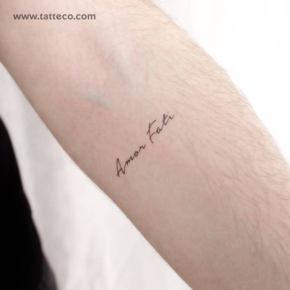 "Amor Fati" temporary lettering tattoo located on the inner forearm.