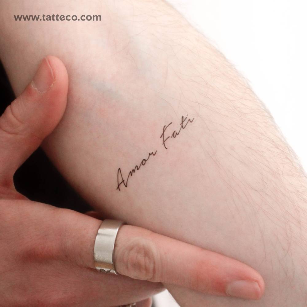 "Amor Fati" temporary lettering tattoo located on the inner forearm.
