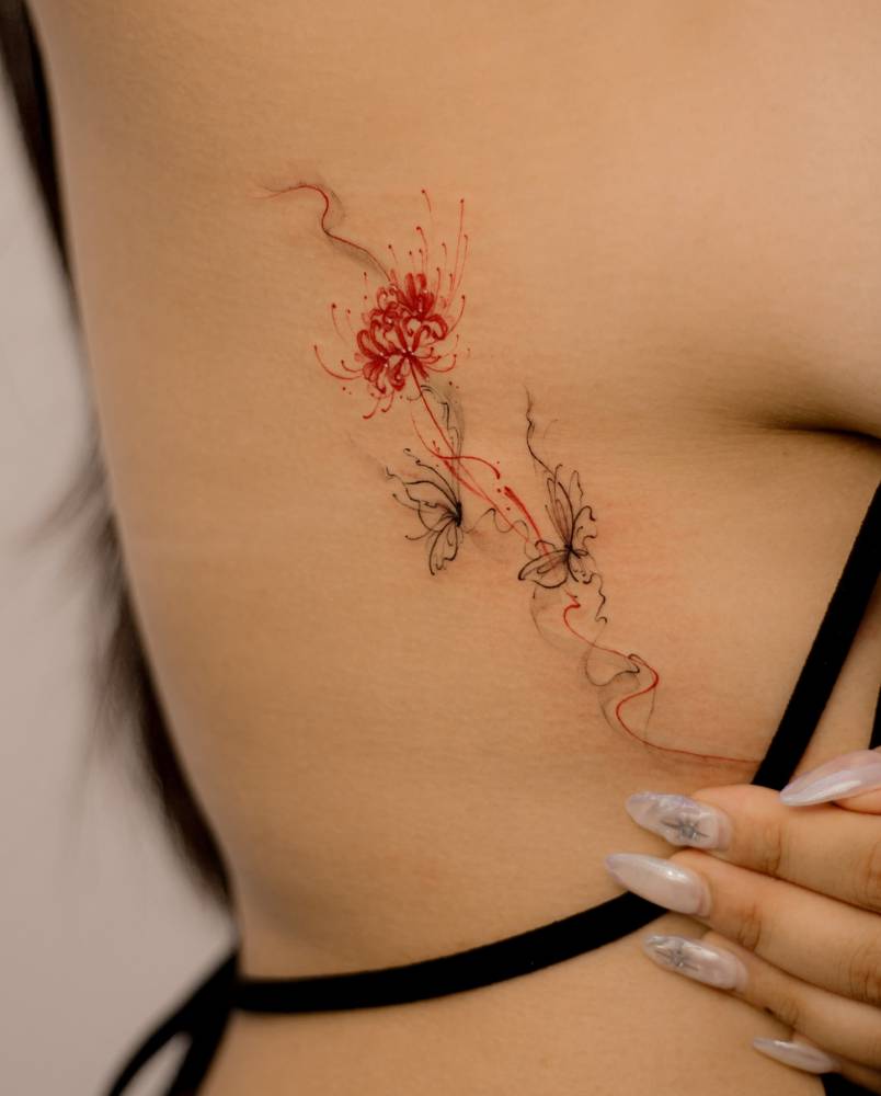 Illustrative style red spider lily tattoo located on the rib.