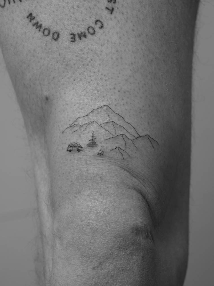 Mountain landscape tattoo located on the thigh, fine line style.